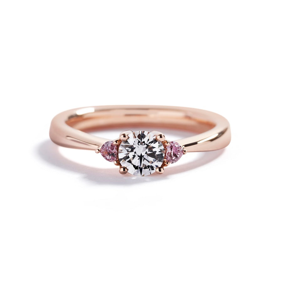 Copenhagen Heart 3-stensring i 18 kt. rosaguld prydet med en 0,52 ct. Top Wesselton(G)/VS1 brillant, flankeret af 2 Natural Fancy Intense Pink/VS1-SI1 hjerteslebne diamanter, i alt 0,11 ct.                                                                                            GIA certifikat medfølger.
