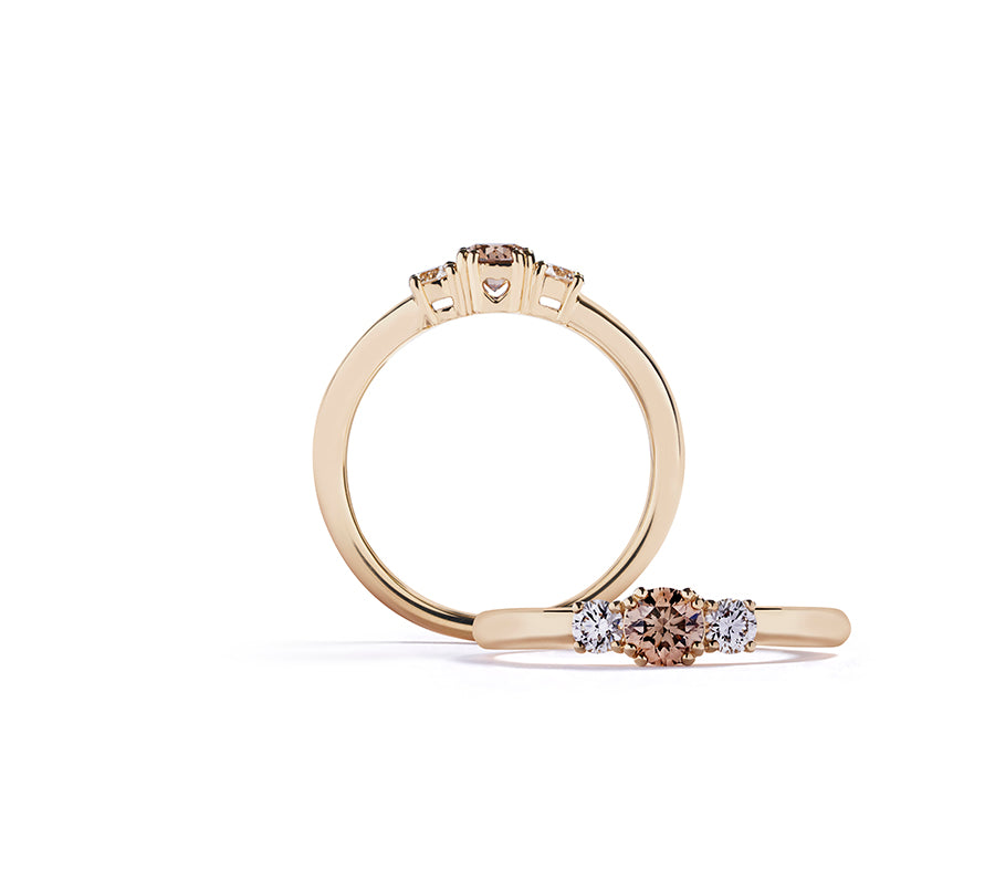 "Copenhagen Love" 3-stensring i 18 kt. gulguld prydet med en 0,31 ct. champagne C5/VS1 brillant, flankeret af to Top Wesselton/VVS-VS brillanter, i alt 0,20 ct.