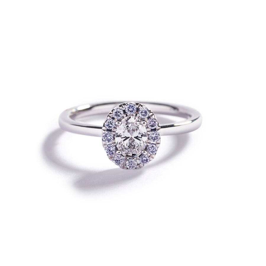 Rosetring i 18 karat hvidguld prydet med en oval 0,47 ct. River(D)/VS2 diamant, omkranset af 12 Natural Fancy Intense Blue/VS-Si brillanter, i alt 0,19 ct.